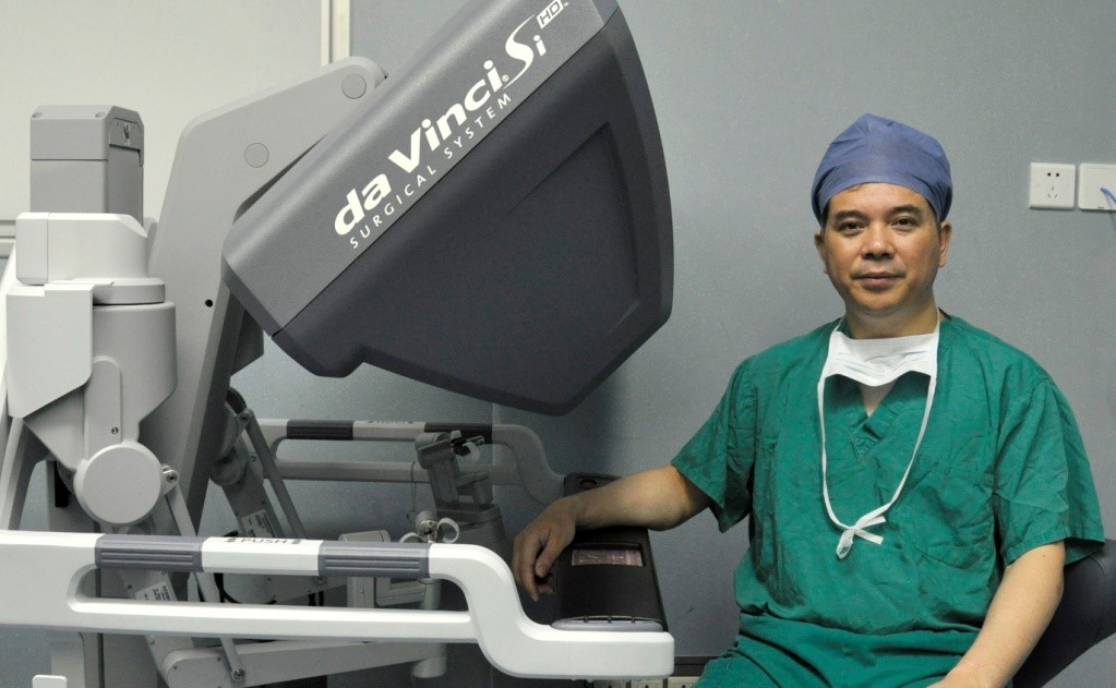 张大宏坐在智能化手术机器人旁。受访者供图