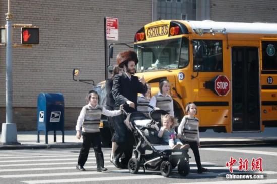 当地时间5月17日，民众从美国纽约市犹太社区的一所学校外经过。当日，纽约州州长科莫表示，纽约州将从19日起全面执行美国疾病控制和预防中心针对新冠疫情发布的新指南。完全接种新冠疫苗的民众可不戴口罩、不保持社交距离，但在公共交通、养老院、监狱、学校等场所仍须戴口罩，其他营业场所也可在此基础上制定具体防疫规定。 <a target='_blank'  data-cke-saved-href='http://www.chinanews.com/' href='http://www.chinanews.com/'><p  align=
