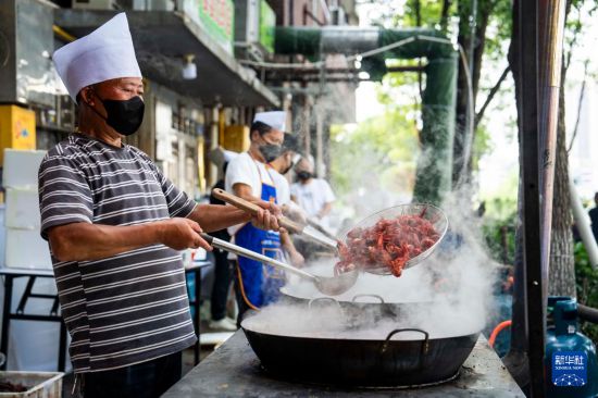 5月16日，在南县沿湖路一家餐饮店，工作人员在烹饪小龙虾。